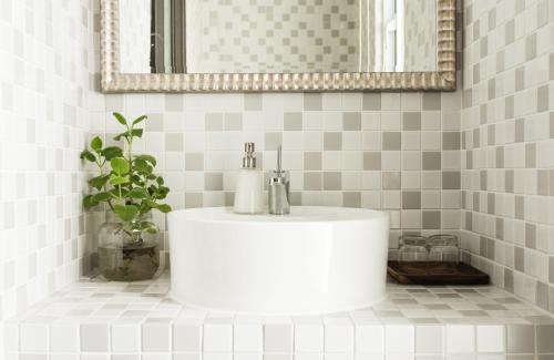 lavabo blanco en el baño con espejo en Zeroplus旅宿 渡假包棟villa, en Hengchun