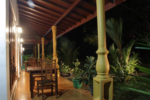 a porch with a table and chairs and plants at Sigiriya Ranasinghe Nature Villa & Cabana in Sigiriya