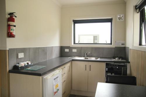 a kitchen with a sink and a window at Geraldine TOP 10 Holiday Park in Geraldine