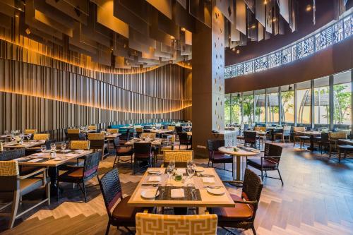 منتجع وفلل أفاني هوا هين في تشا أم: غرفة طعام بها طاولات وكراسي ونوافذ كبيرة