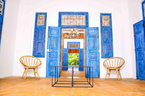 two chairs and a table in front of a door at Handun Villas in Talalla