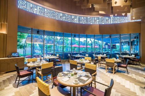 منتجع وفلل أفاني هوا هين في تشا أم: مطعم به طاولات وكراسي ونوافذ كبيرة