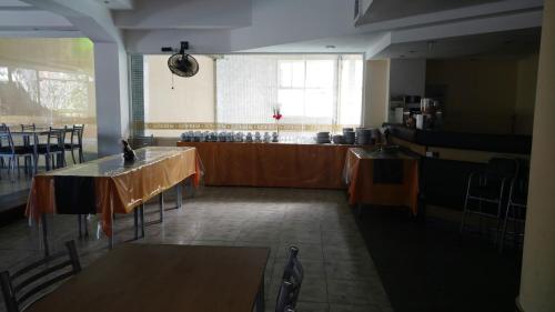 a dining room with tables and chairs and a counter at San Remo World Hotel in San Clemente del Tuyú