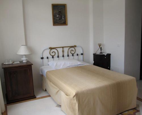 a bedroom with a bed and a nightstand with a lamp at Hotel Santa Marina Antica Foresteria in Santa Marina Salina