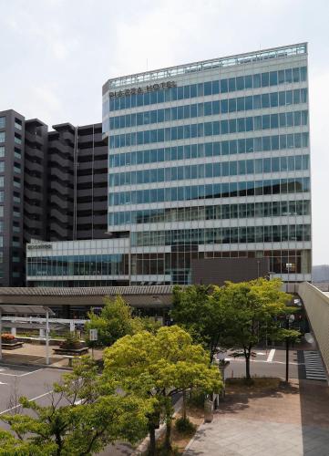 a large glass building with trees in front of it at Piazza Hotel Nara in Nara