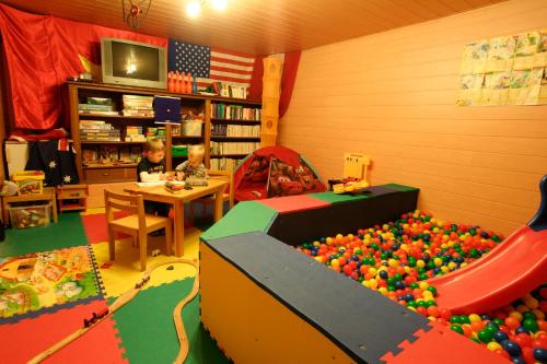 two children sitting at a table in a room full of balls at Landhaus Seebacher in Spital am Pyhrn
