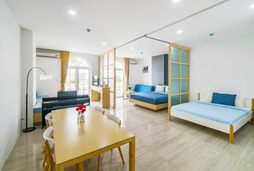 a room with two beds and a table and a desk at Babylon D3 Serviced Apartment in Ho Chi Minh City