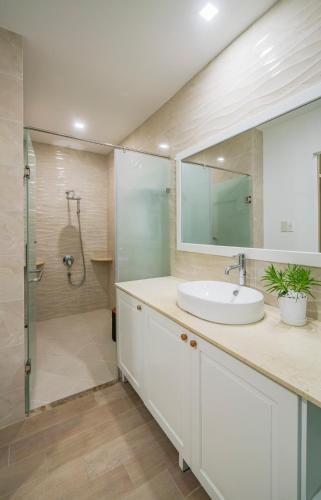 a bathroom with a white sink and a shower at Babylon D3 Serviced Apartment in Ho Chi Minh City