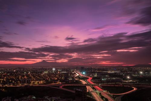 una vista di una città di notte con un cielo viola di Laviu B&B Luxe Suites a Puebla