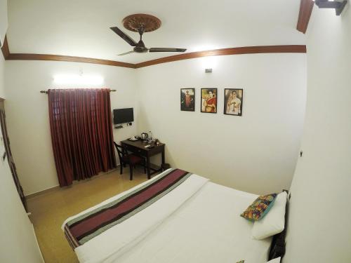 a bedroom with a bed and a desk in it at Sapphire Club Cherai Beach Villa in Cherai Beach