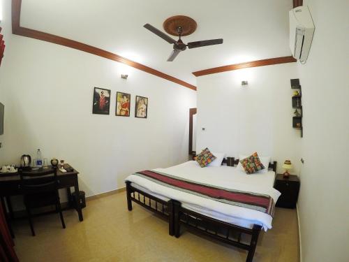 1 dormitorio con cama y escritorio con techo en Sapphire Club Cherai Beach Villa en Cherai Beach