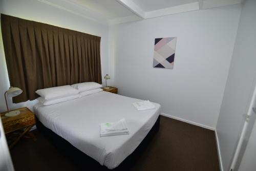 a bedroom with a white bed and white walls at City Centre Apartments in Grafton