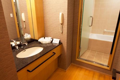 a bathroom with a sink and a shower at Hotel Grand Arc Hanzomon in Tokyo