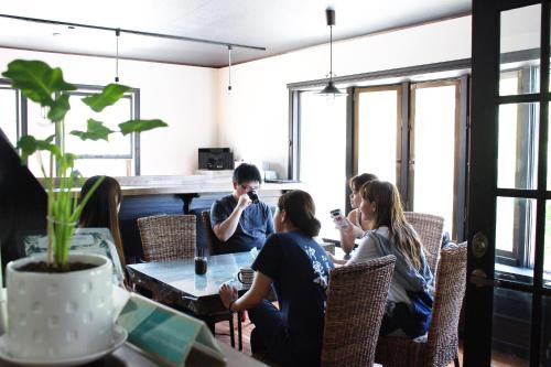 a group of people sitting at a table in a restaurant at Nangoku Lodge Booya in Onna