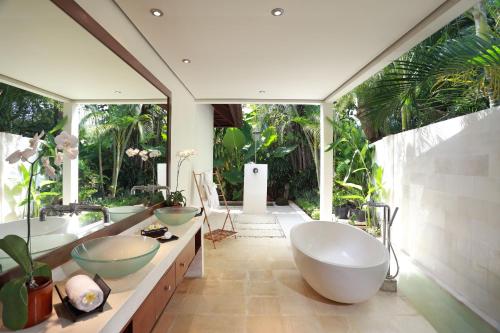 uma casa de banho com 2 lavatórios e uma grande janela em Villa Bali Asri em Seminyak