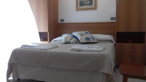 a bed with two pillows on top of it at Villa Laura Residence Hotel Apartments & Studios in Ascea