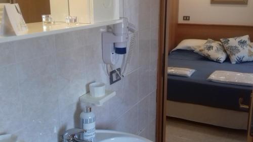 a bathroom with a sink and a bedroom with a bed at Villa Laura Residence Hotel Apartments & Studios in Ascea