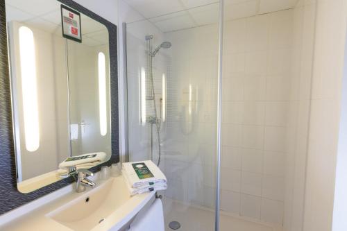 a bathroom with a shower and a sink and a mirror at ibis Dunkerque in Dunkerque