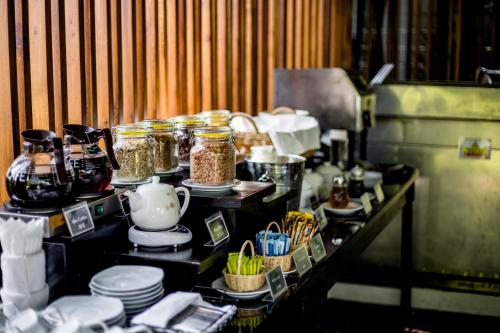 een toonbank met potten, borden en andere spullen bij Aruntara Riverside Boutique Hotel in Chiang Mai
