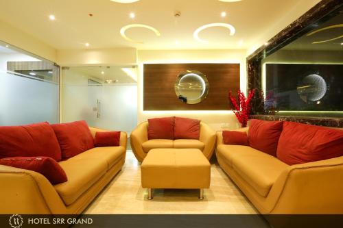 a living room with two couches and a table at Hotel SRR Grand in Chennai
