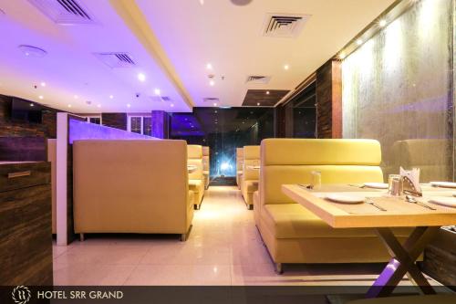 a restaurant with a table and chairs in a room at Hotel SRR Grand in Chennai