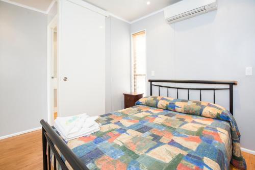 a bedroom with a bed with a colorful quilt at Townsville Lakes Holiday Park in Townsville