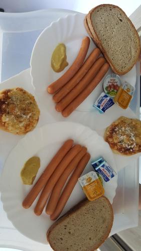 a white plate with hot dogs and bread on it at Ubytování Němčičky in Němčičky