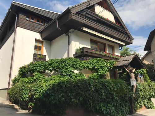a man holding an umbrella in front of a house at Apartmaji Sušnik in Bled