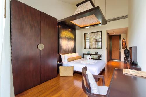 a hotel room with a bed and a desk at Beachfront Villa Baan Paradise in Laem Set Beach