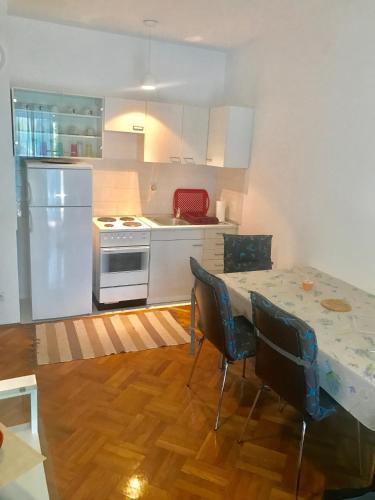a kitchen with a white refrigerator and a table with chairs at Lux dodo in Dramalj