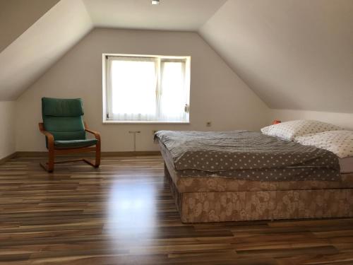 ein Schlafzimmer mit einem Bett, einem Stuhl und einem Fenster in der Unterkunft Dom V Zahrade in Turčianske Teplice