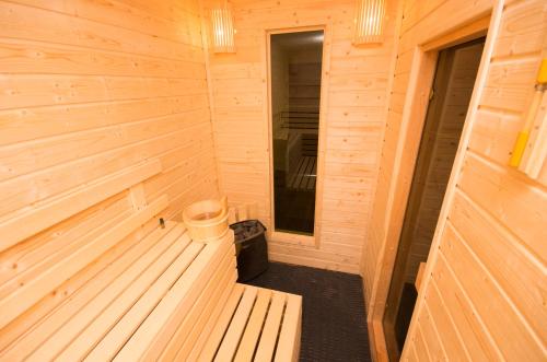una sauna de madera con cubo y cubo de basura en Sziklakert Fogadó en Sâncrai