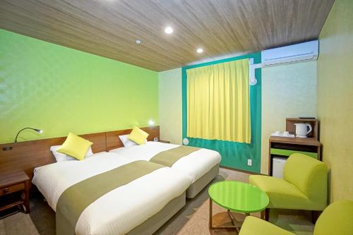 a bedroom with a large bed and a green wall at La'gent Hotel Tokyo Bay in Urayasu
