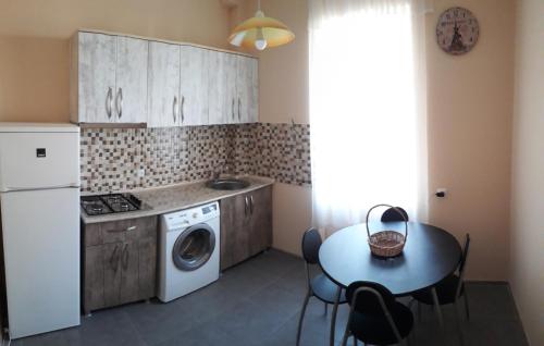 a kitchen with a washing machine and a table at Comfortable Apartment close to Central Park in Tskaltubo