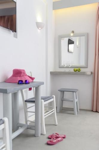 a table with a pink bag and a table and chairs at Naxian Althea in Agia Anna Naxos