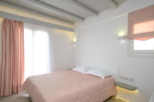 a bedroom with a bed and a large window at Naxian Althea in Agia Anna Naxos