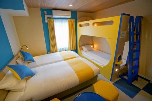 a bedroom with two bunk beds and a ladder at La'gent Hotel Tokyo Bay in Urayasu