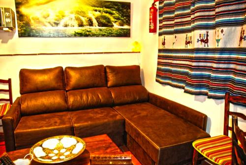 a living room with a brown leather couch and a window at Cazorla Rural in Quesada