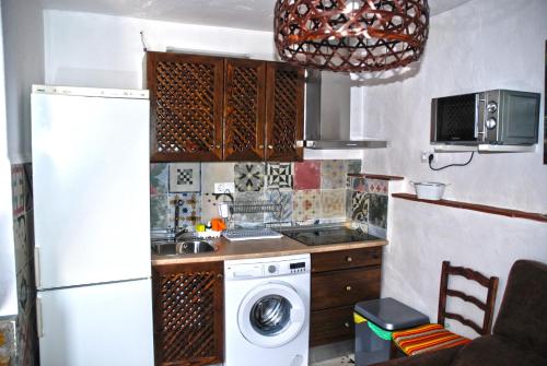 a kitchen with a refrigerator and a washing machine at Cazorla Rural in Quesada