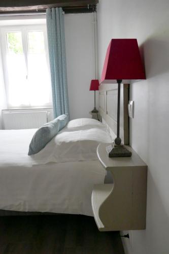 a bedroom with a bed with a red lamp and a window at Domaine d'Adon in Adon