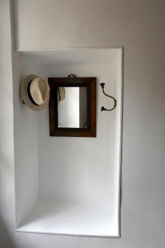 a hat and a mirror on a white door at Domaine d'Adon in Adon