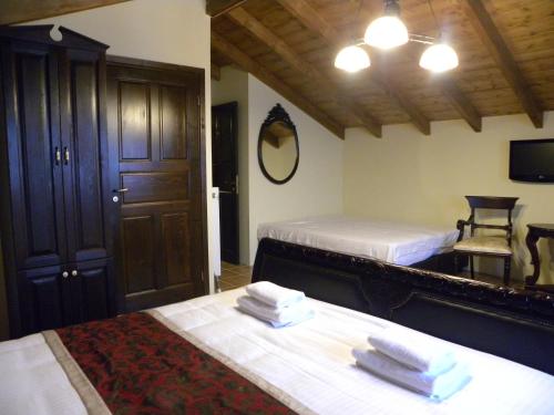 une chambre avec deux lits et un miroir dans l'établissement Argyro Guesthouse - Ξενώνας Αργυρώ, à Nymfaio
