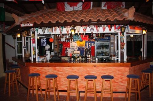 a bar with six bar stools in front of it at Eleni Apartments in Hersonissos