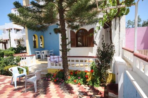 a tree and a bench in front of a house at Eleni Apartments in Hersonissos