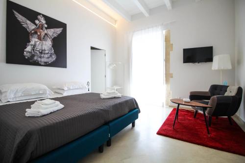 sypialnia z łóżkiem, krzesłem i stołem w obiekcie Re Federico Boutique Hotel w Syrakuzach
