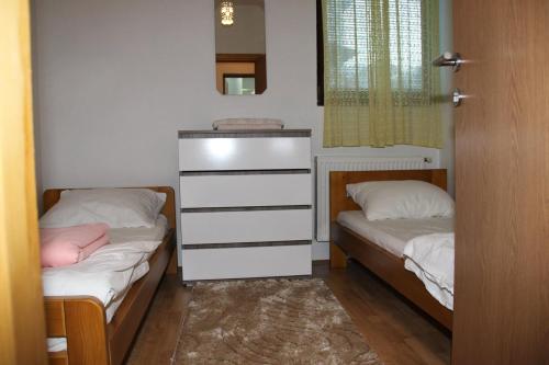a bedroom with two beds and a dresser in it at VIP Rooms Foča, Accommodation Foca, Foca Rooms in Foča