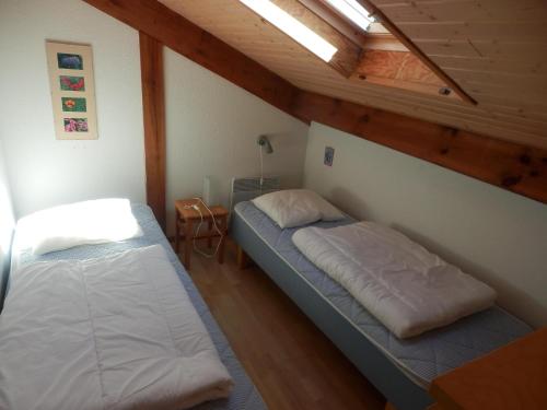 deux lits dans une chambre avec plafonds en bois dans l'établissement Park Village Océlandes, à Saint-Julien-en-Born