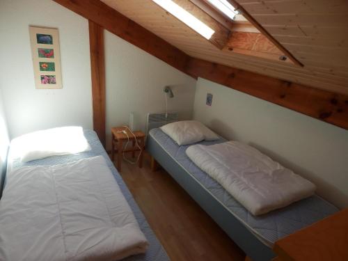 two beds in a room with wooden ceilings at Park Village Océlandes in Saint-Julien-en-Born