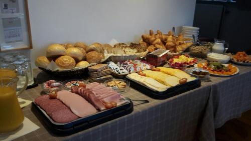 uma mesa com diferentes tipos de alimentos e pão em Golf Hotel Mergelhof em Gemmenich