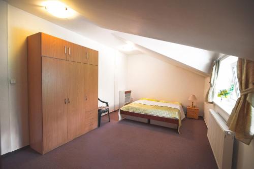 een slaapkamer met een bed en een grote houten kast bij Apartmán Relax in Smižany
